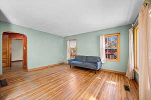 Lots of character with archways, hardwood floors, and wood-trimmed windows