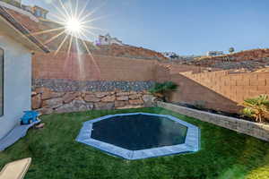 Fenced backyard featuring a patio and a trampoline