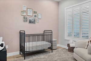 Bedroom featuring a crib and light wood-style flooring