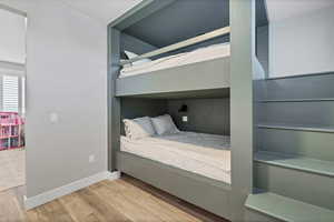 Bedroom with light wood finished floors and baseboards