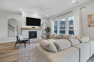 Living area featuring recessed lighting, wood finished floors, a ceiling fan, and a fireplace