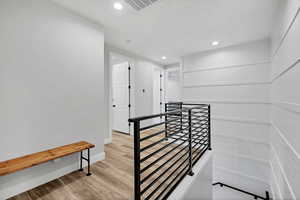 Stairs with recessed lighting and wood finished floors