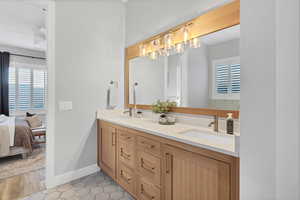 Bathroom featuring double vanity, ensuite bathroom, and light tile patterned flooring