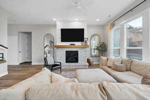 Living room featuring a brick fireplace, wood finished floors, recessed lighting, and a ceiling fan