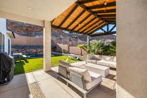 Fenced backyard featuring a patio, a mountain view, an outdoor living space, and grilling area