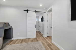 Interior space featuring light wood-type flooring, recessed lighting, and a barn door