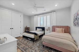 Bedroom with wood finished floors, a closet, recessed lighting, and a ceiling fan
