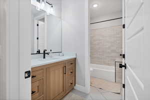 Bathroom with vanity, light tile patterned floors, and bathing tub / shower combination