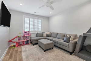 Living room with light wood finished floors, recessed lighting, and a ceiling fan