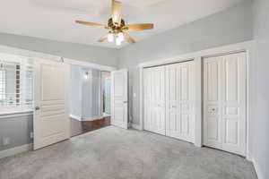 Bedroom with carpet flooring, closets, French doors, ceiling fan, and vaulted ceiling