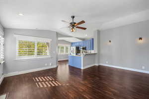 Living room featuring dark wood finished floors, vaulted ceiling, recessed lighting, and a ceiling fan
