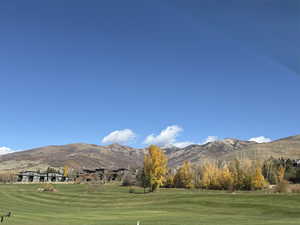 View of property's community featuring a yard, a mountain view, and golf course view