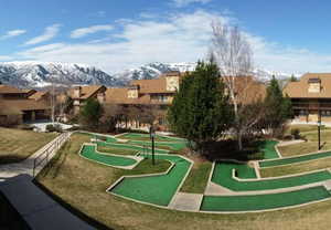 View of community with a putting area, a mountain view, a residential view, and a yard