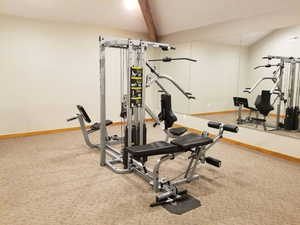 Exercise room featuring beam ceiling and light carpet