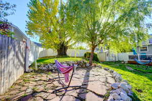 Fenced backyard with a patio and a storage unit