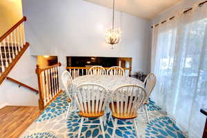 Dining space with wood finished floors and a chandelier