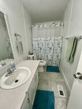 Bathroom featuring vanity, curtained shower, and light tile patterned floors