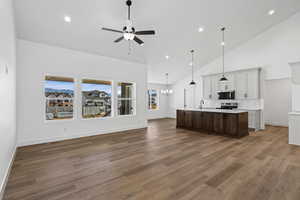 Kitchen featuring open floor plan, high vaulted ceiling, pendant lighting, recessed lighting, and a chandelier