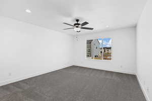 Unfurnished room with dark colored carpet, a ceiling fan, and recessed lighting