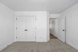 Unfurnished bedroom featuring carpet floors and a closet