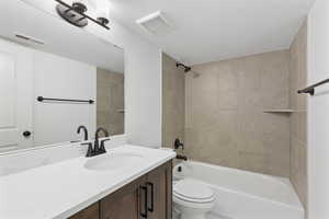 Bathroom with bathtub / shower combination, a textured ceiling, and vanity