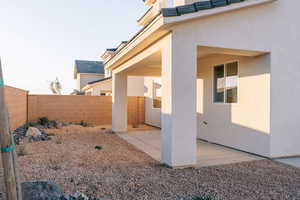 View of side of property with stucco siding, a fenced backyard, and a patio area