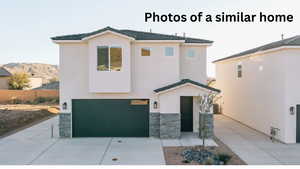 View of front of home with stone siding, an attached garage, driveway, and stucco siding