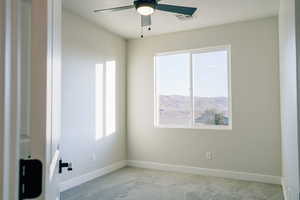 Spare room featuring light carpet, a mountain view, and ceiling fan