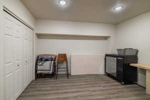 Living area with light wood-style flooring and recessed lighting