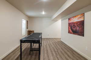 Recreation room featuring wood finished floors and baseboards