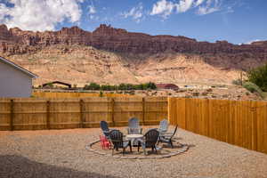 Fenced backyard featuring a patio, a mountain view, and a fire pit