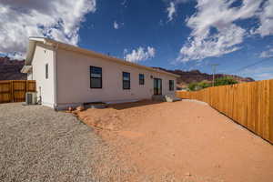 Rear view of house featuring a fenced backyard, a mountain view, a patio area, and stucco siding