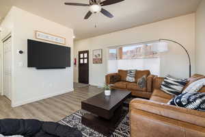 Living room with light wood-style floors and ceiling fan