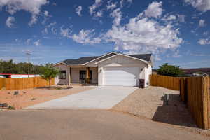 Single story home with driveway, a garage, a shingled roof, and covered porch