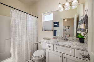 Full bathroom featuring vanity, shower / tub combo, and ceiling fan