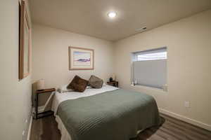 Bedroom featuring baseboards and dark wood-type flooring