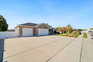 View of front of home featuring concrete driveway, a garage, brick siding, and a shingled roof