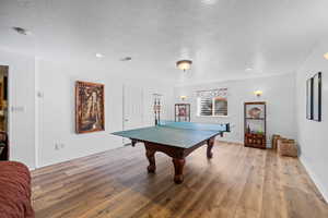 Playroom featuring light wood-type flooring and a textured ceiling