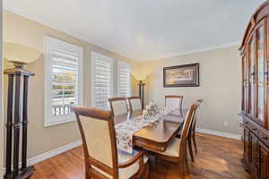 Dining area with wood finished floors and ornamental molding