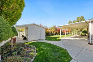 View of green lawn featuring an outbuilding