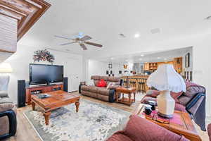 Living room featuring wood finished floors, a textured ceiling, and recessed lighting