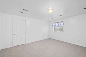 Empty room with carpet floors and a textured ceiling