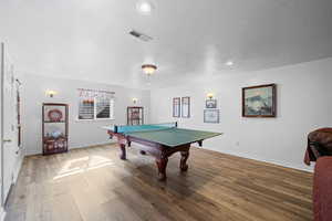 Rec room featuring wood finished floors, a textured ceiling, and recessed lighting