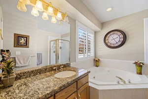 Full bathroom featuring a whirlpool tub, a stall shower, vanity, and recessed lighting