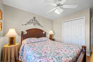 Bedroom featuring wood finished floors, ceiling fan, and a closet