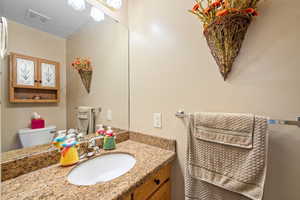 Half bathroom with vanity and toilet