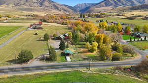 Aerial view of property and surrounding area featuring rural landscape and mountains