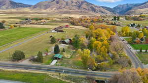 Aerial view of property and surrounding area featuring a mountainous background and rural landscape