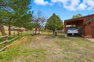 View of yard with a carport and a view of rural / pastoral area