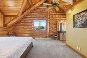 Bedroom with carpet flooring, rustic walls, ceiling fan, a baseboard radiator, and wooden ceiling